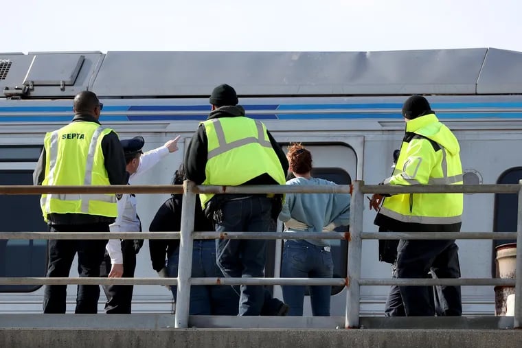 Officials examine the top of an El car  after a body was found on top of it at the Market-Frankford Line's Girard Avenue station on Feb. 3, 2020.