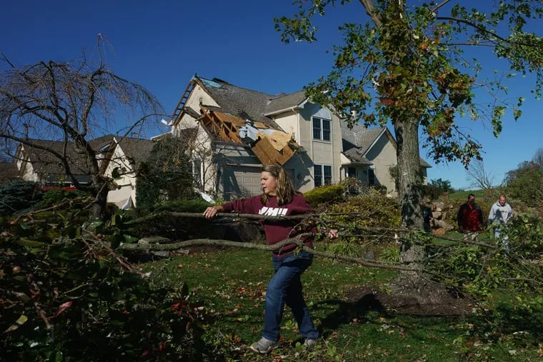 Cindy Bevilacqua helps with the cleanup in her daughter's yard on Chelsea Court in Thornbury Township, Delaware County, where an EF-2 tornado -- rare for this time of year -- tore through Halloween night.