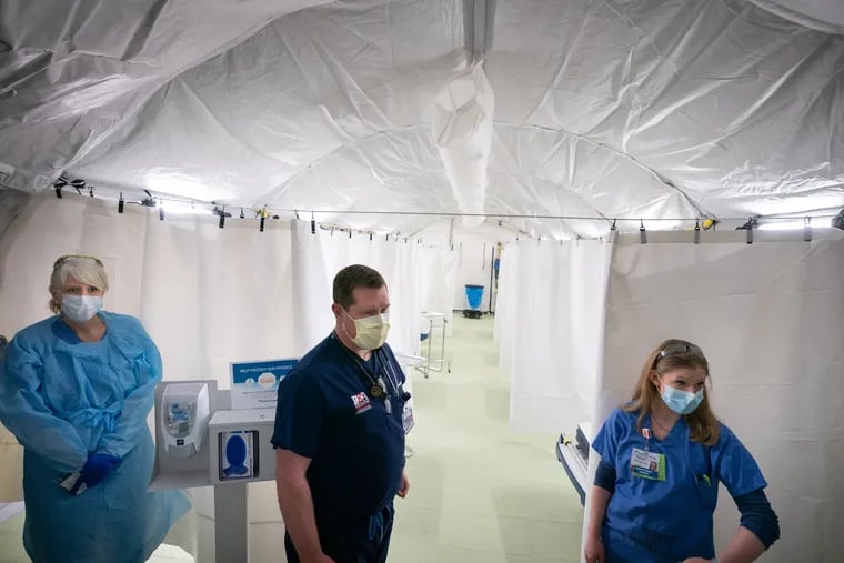 (Left to Right) Gina Rex, RN, Dr. Michael Goodyear, DO, Emergency Department Physician, Nurse Tracey Jefferson, RN, Emergency Department Nurse, inside the new emergency response tent during a media tour of the facility at Doylestown hospital, the emergency response tent will centralize diagnosis and initial treatment for those with respiratory symptoms suggesting COVID-19, in Doylestown, PA, March 30, 2020. JESSICA GRIFFIN / Staff Photographer