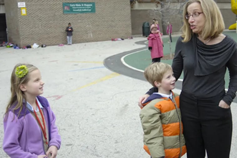 Christine Carlson, a force behind the Greater Center City Neighborhood School Coalition, outside Greenfield Elementary School with her two children, who are students there. (Alex Remnick / Staff Photographer)