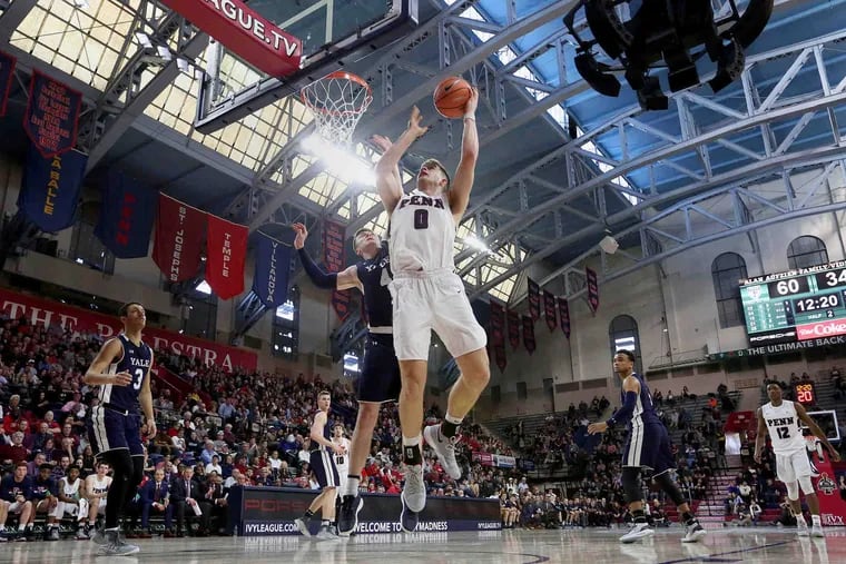 Penn forward Max Rothschild (0) puts the ball up past Yale forward Noah Yates (4) during their Ivy League tournament semifinal game at the Palestra on Saturday, March 10, 2018. Penn won 80-57.