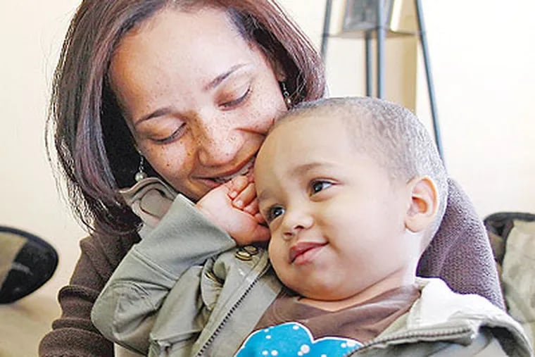 Kheli Muhammad , of Overbrook, holds her son Samad, 2. He has a cardiac pacemaker but was removed from Medicaid rolls. (Yong Kim / Staff Photographer)