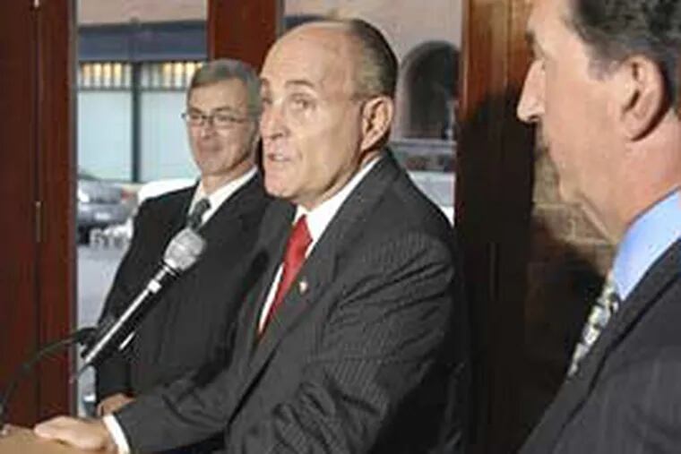Republican presidential candidate Rudy Giuliani, center, speaks during a news conference Tuesday in Boston. He was endorsed by former Massachusetts treasurer Joseph Malone, right. Former Massachusetts Gov. Paul Celluci, left, had previously endorsed Giuliani.