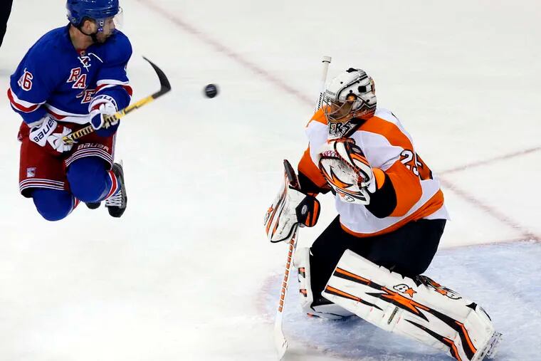 Rangers winger Martin St. Louis, who scored New York's first goal, tries to swat the puck past Flyers goaltender Ray Emery in the first period of Game 2.