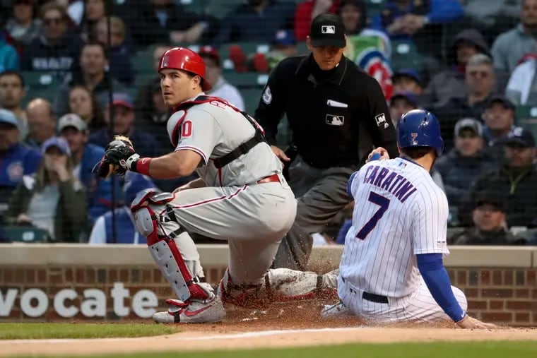 Catcher J.T. Realmuto tags Chicago's Victor Caratini out at home plate in the second inning of the Phillies' 5-4 win Monday night.