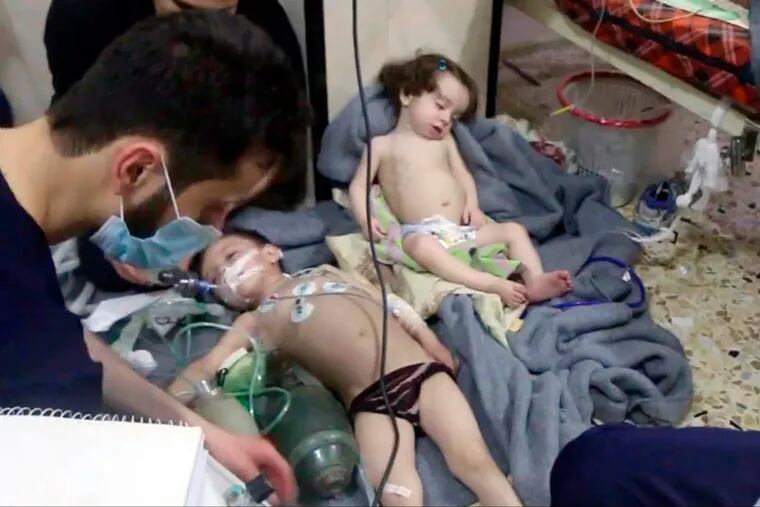 Image made from video released by the Syrian Civil Defense White Helmets, shows medical workers treating toddlers following an alleged poison gas attack in the opposition-held town of Douma, near Damascus, Syria.