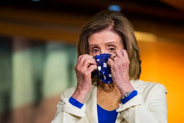 House Speaker Nancy Pelosi adjusts her face mask during a news conference on Capitol Hill on Thursday.