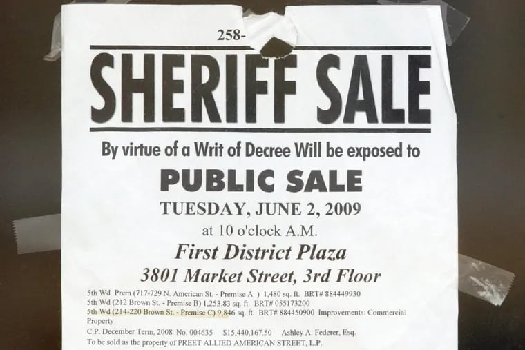 A sheriff sale notice is taped to a window in May 2009. 
