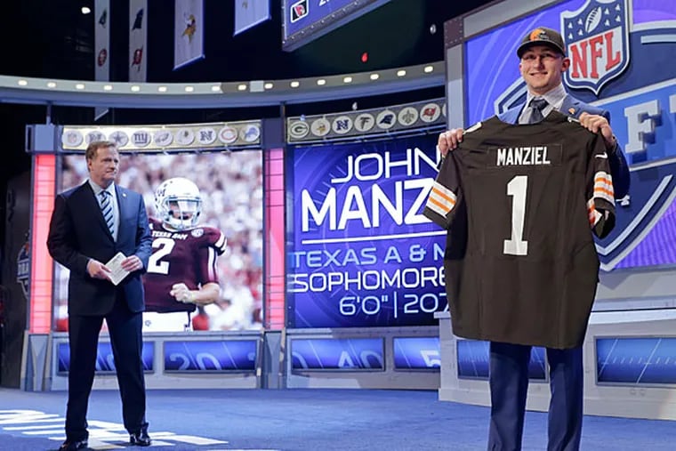 Texas A&M quarterback Johnny Manziel poses for photos after being selected by the Cleveland Browns as the 22nd pick in the first round of the 2014 NFL Draft, Thursday, May 8, 2014, in New York. (Craig Ruttle/AP)