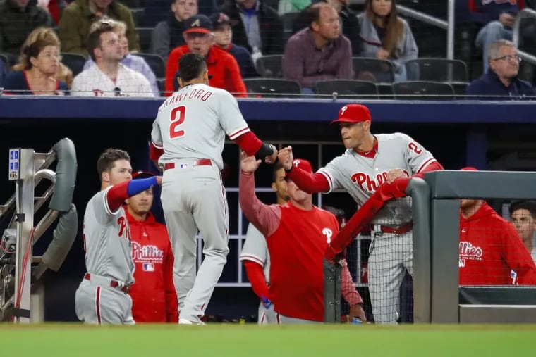 Phillies shortstop J.P. Crawford (2) celebrates with manager Gabe Kapler after scoring in the third inning of the Phillies’ loss on Friday.