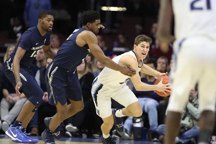 Collin Gillespie, 2nd from right, of Villanova looks to pass the ball to teammate Dhamir Cosby-Roundtree, right, as he drives up court against the trapping defense of Naji Marshall, left, and Quentin Goodin, 2nd from left, of Xavier during the 2nd half at the Wells Fargo Arena on Jan. 18, 2019.