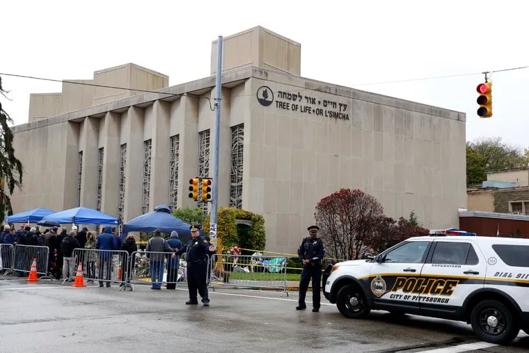Pittsburgh Police direct traffic as their vehicles close the street adjacent to the Tree of Life Synagogue on Saturday, Nov. 3, 2018, as a curbside Shabbat morning service is held on the street corner in the Squirrel Hill neighborhood of Pittsburgh. The service honored the 11 people killed by a gunman, Oct 27, 2018 while worshiping at the Tree of Life Synagogue.