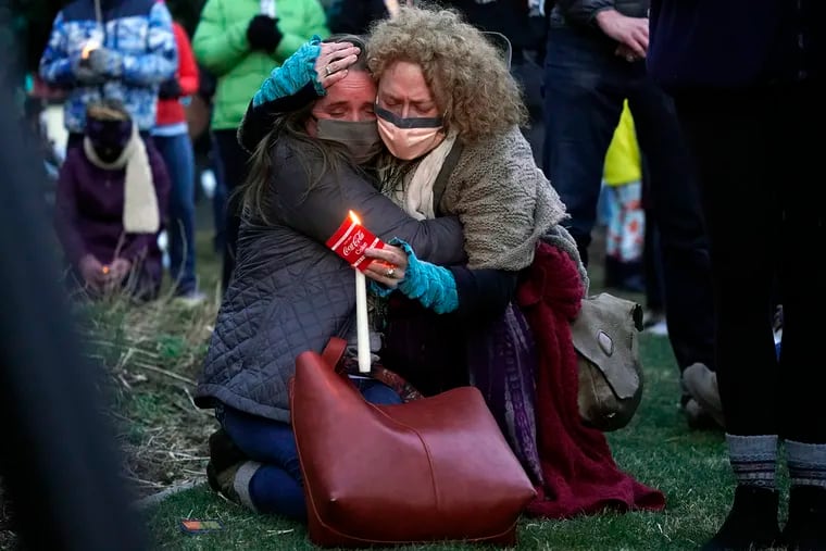 Mourners hug at a vigil for the victims of a mass shooting at a grocery store earlier in the week outside the courthouse in Boulder, Colo.