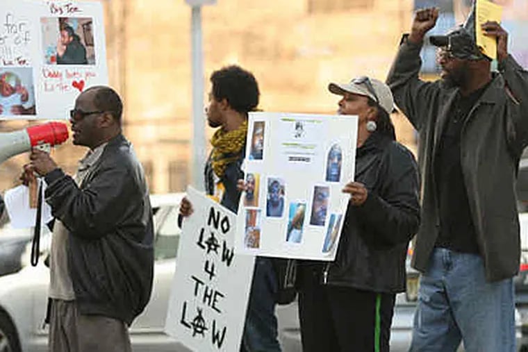 Protesters gather outside Fraternal Order of Police headquarters while officers welcome the return of three colleagues fired over the Fox29-videotaped beatings. (Jimmy Viola / Staff Photographer)