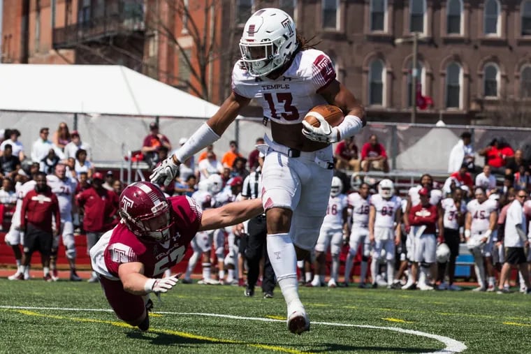 White team's wide receiver Isaiah Wright (right) pushes Cherry team's offensive lineman Isaac Moore down to the ground as he attempts to tackle Wright during Temple's Cherry and White spring football game at the Temple Sports Complex on Saturday, April 14, 2018. SYDNEY SCHAEFER / Staff Photographer