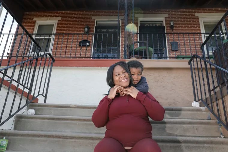 Tiearra Sampson and her 4-year-old son, Zaiden Miles, on the front steps of her mother's West Philadelphia rowhouse on Easter. Sampson, who is 28 weeks pregnant, is among a growing number of local women who are seeking home births because they fear being exposed to coronavirus during labor and delivery at hospitals.