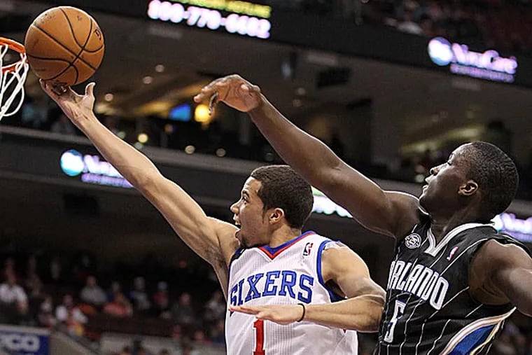 The Sixers' Michael Carter-Williams drives to the basket past the Magic's Victor Oladipo during the second quarter. (Yong Kim/Staff Photographer)