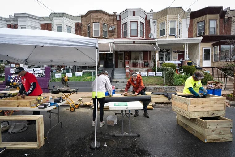 Volunteers from the nonprofit Rebuilding Together Philadelphia work on houses in West Philly on Friday, April 12, 2024.