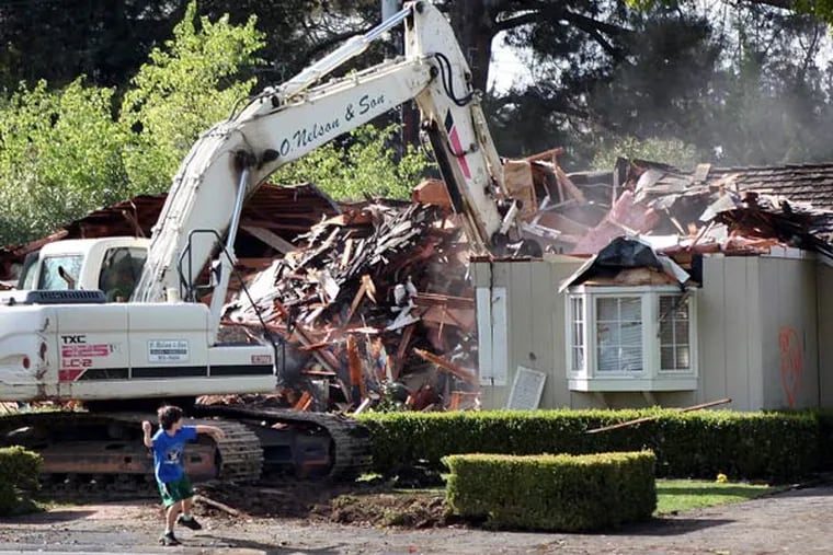 Matthew Bergeron, 9, helps crews demolish his home in Menlo Park, Calif., by throwing a rock through a window, Feb. 27, 2014. The family found it more cost-effective to build a new house on that lot than to remodel the 67-year-old, slab foundation structure. (Karl Mondon/Bay Area News Group/MCT)