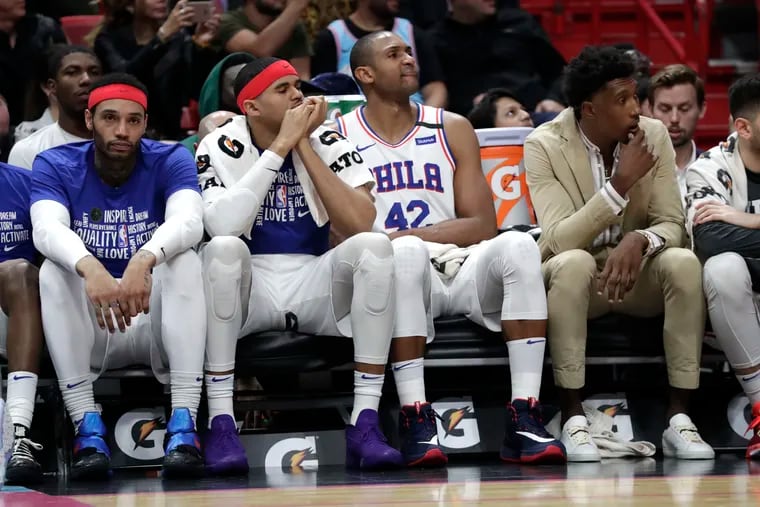 Sixers reserve forward Mike Scott, left, watches from the bench with small forward Tobias Harris, center,  forward Al Horford (42) and guard Josh Richardson, right, during the closing minutes of Monday's loss to the Miami Heat.