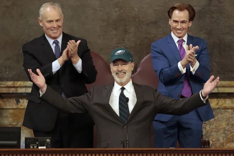 Democratic Gov. Tom Wolf puts on a Philadelphia Eagles hat to celebrate their Super Bowl win before he gives his budget address at the state Capitol in Harrisburg, Pa., on Tuesday, Feb. 6, 2018. (AP Photo/Chris Knight)