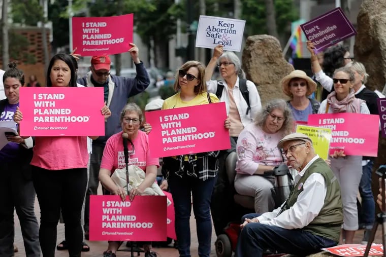 Protesters hold signs supporting Planned Parenthood in Seattle in July, as they demonstrate against President Donald Trump  (AP Photo/Ted S. Warren, File)