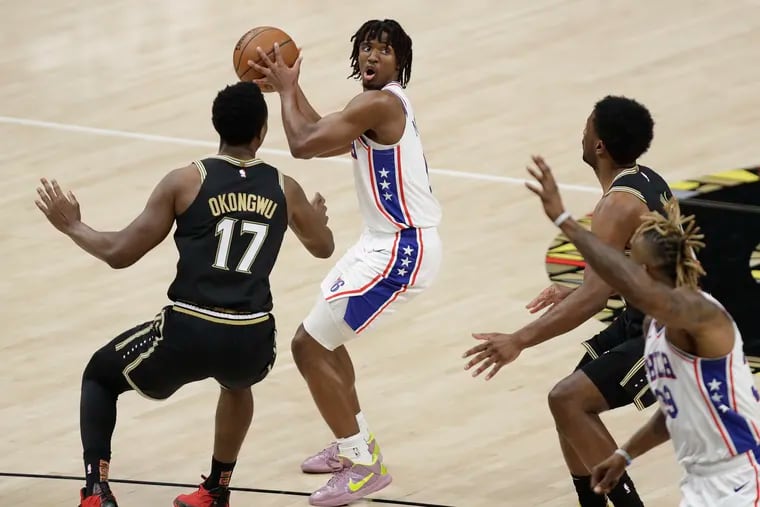 Sixers guard Tyrese Maxey looks to pass the basketball to teammate center Dwight Howard against Atlanta Hawks forward Onyeka Okongwu and guard Lou Williams in Game 6 of the NBA Eastern Conference playoff semifinals on Friday, June 18, 2021 in Atlanta.