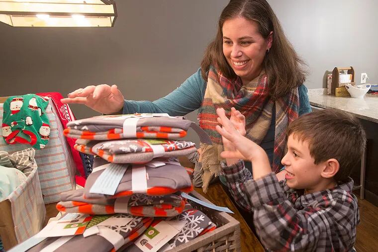 Pamela Badolato and son Jimmy organize PJ packages. She hopes to collect 1,000 pairs for charities.
