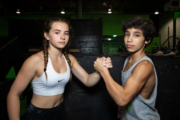 Avery Glantz, 14, and Cal Plohoros, 13, join hands for a portrait at iCore Fitness in West Chester, Pa. on Thursday, July 11, 2019. Glantz headed to Los Angeles to compete in the American Ninja Warrior Junior Competition for the first time while Plohoros went for his second season. "I want to make it passed the first round as for my goal," Glantz said. "I'm nervous but I'm more excited for the opportunity and seeing all my friends."