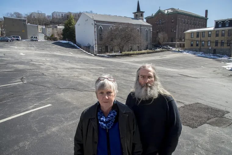 Irene Madrak (left), executive director of North Light Community Center in Manayunk, and Kevin Smith, president of the Manayunk Neighborhood Council, stand in the parking lot of St. Mary of the Assumption Church.