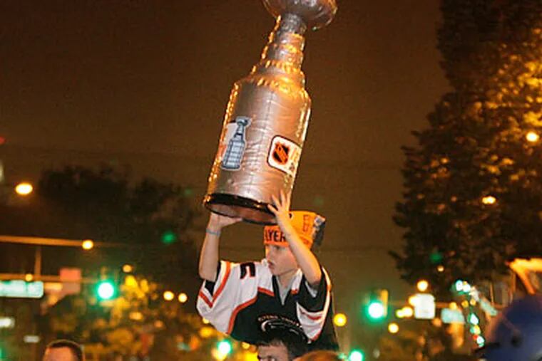 A young fan brought his own Stanley Cup to the postgame celebrations at Broad and Shunk after the Flyers beat the Canadiens. (Elizabeth Robertson/Staff Photographer)