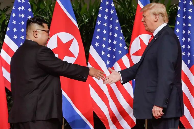 In this June 12, 2018, file photo, U.S. President Donald Trump reaches to shake hands with North Korea leader Kim Jong Un at the Capella resort on Sentosa Island in Singapore.