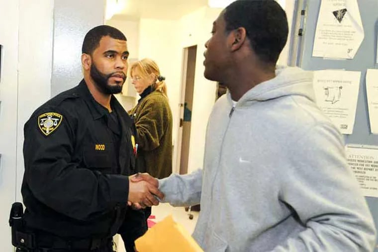 Corrections officer Terrell Wood shakes hands with Jamal Thompson and offers him advice just before he is released. (Ron Tarver / Staff Photographer)
