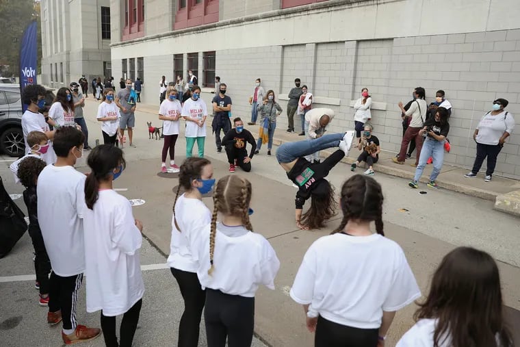 Rachel Snider, an instructor at Movemakers Philly, shows off her moves as the program's students perform for people waiting in line to cast their mail-in ballots at the High School for Creative and Performing Arts in South Philadelphia on Saturday.
