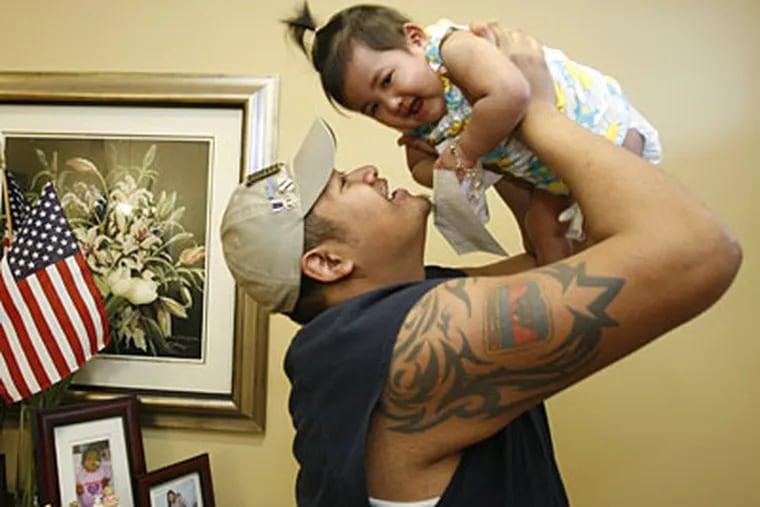 Pisey Tan lifts his daughter, Alyssa, as they play in their Woodlyn home. Tan, medically retired from the Army, lost both legs when a bomb exploded under his military vehicle in Iraq. (CHARLES FOX / Staff Photographer)