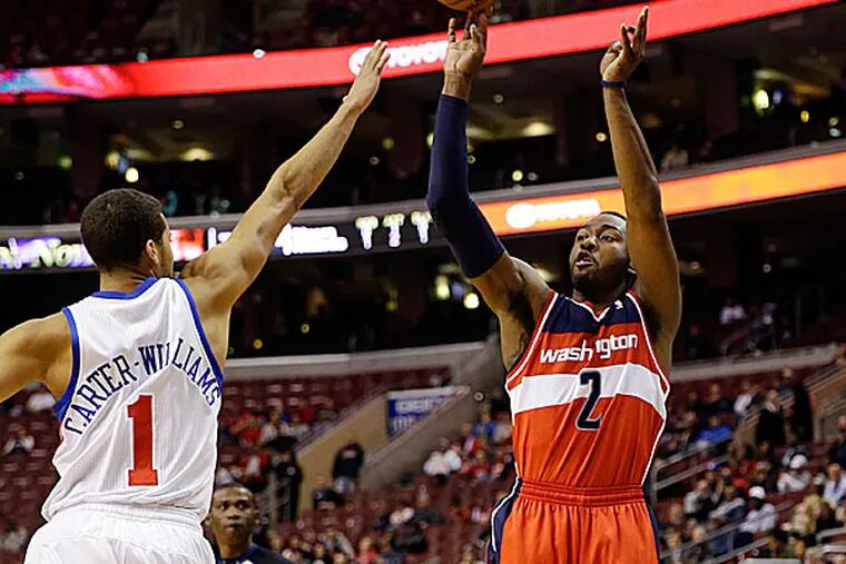 The Wizards' John Wall goes up for a shot against the 76ers' Michael Carter-Williams. (Matt Slocum/AP)