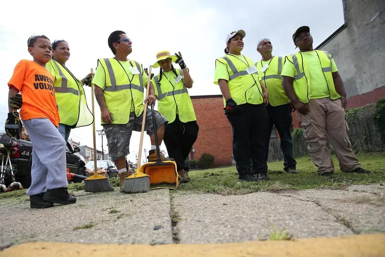 A group takes a break after cleaning up a lot at 6th and York Streets as part of Camden Lutheran Housing, Inc.'s efforts to transform the neighborhood. DAVID MAIALETTI / Staff Photographer