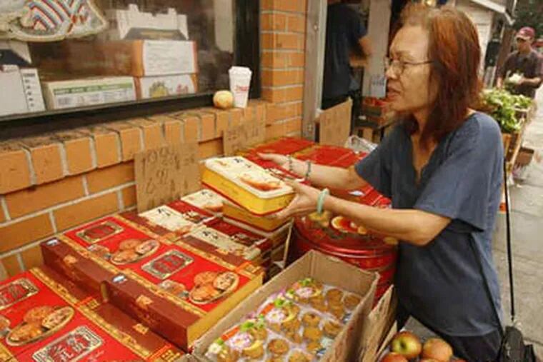 The quest for mooncakes takes Betty Lui to a shop on North 10th Street. Her purchases will be used in the mooncake-eating contest during the Mid-Autumn Festival tomorrow in Chinatown. (Charles Fox / Staff Photographer)