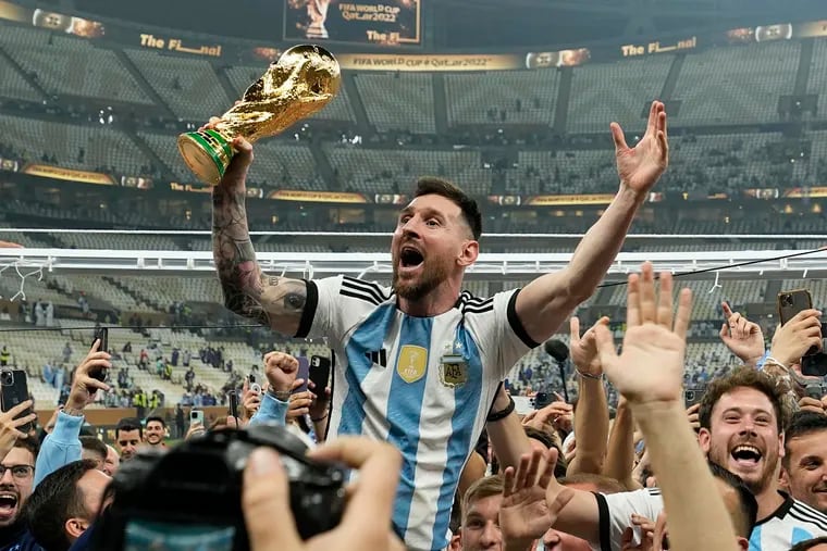 Lionel Messi celebrates with the men's World Cup trophy after he led Argentina to soccer's biggest prize in 2022.
