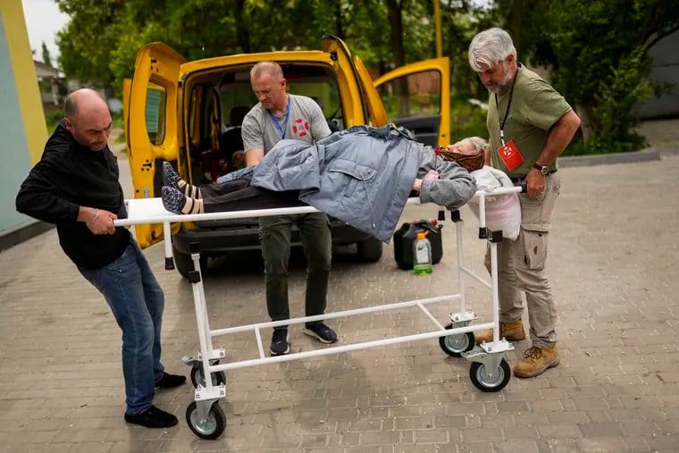 A woman is transferred to a hospital as part of an evacuation from her home in Kramatorsk by volunteers of Vostok SOS charitable organization, in Slovyansk, eastern Ukraine, Thursday, May 26, 2022.