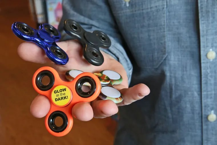 Matthew Poulson, co-owner of Ruckus &amp; Glee in Wauwatosa shows the popular fidget spinners, which look like toys but are being used by adults as well. They fit in your pocket and when you spin them they kind of calm you down.