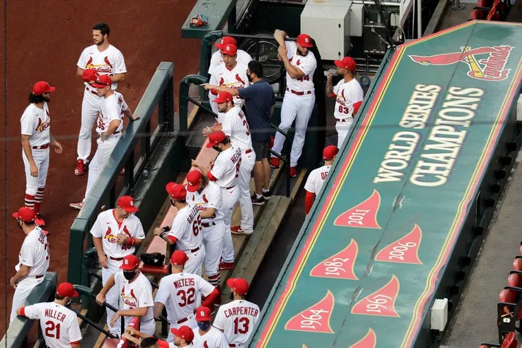 St. Louis Cardinals players and coaches in the team's dugout at Busch Stadium before a game on July 24.