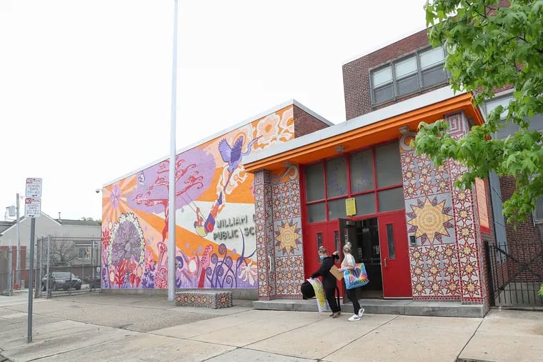 Teachers exit William Dick Elementary in North Philadelphia on Tuesday, May 4, 2021, one in a panther costume to surprise students who had high attendance as part of extra measures to boost morale.