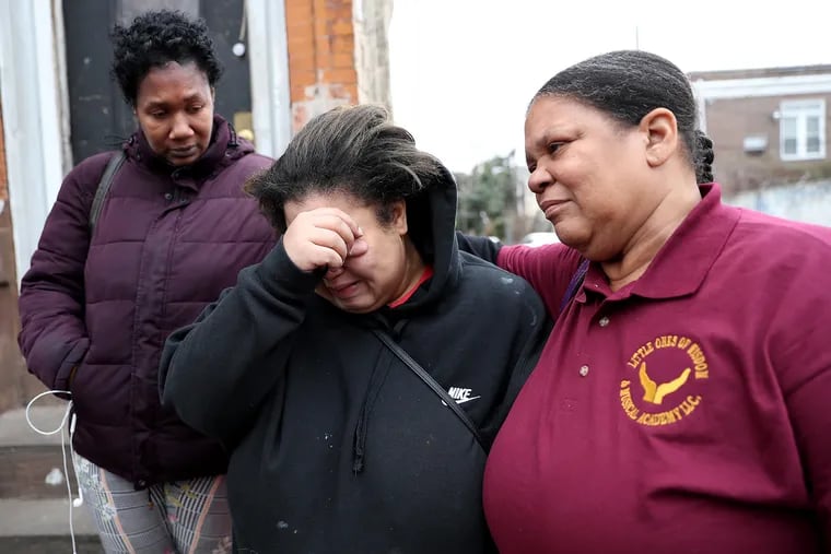 Rasheida Quinn, center, cries as she talks about her son, Demitrius Moore, as Diane Melton, left, and Quinn's mother, Robin Blackwell, right, comfort her near her home in Philadelphia, Pa. on January 13, 2020. Demitrius, 15, was shot and killed on Saturday.