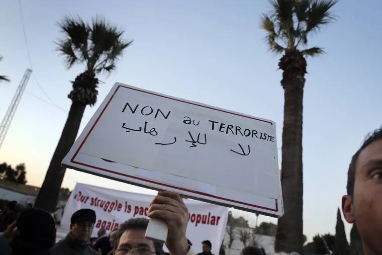 A man holds a placard reading: "No to terrorism" as he demonstrates in front of the National Bardo Museum a day after gunmen attacked the museum and killed scores of people in Tunis, Tunisia, Thursday, March 19, 2015. The Islamic State group issued a statement Thursday claiming responsibility for the deadly attack on Tunisia's national museum that killed scores of people, mostly tourists. (AP Photo/Christophe Ena)