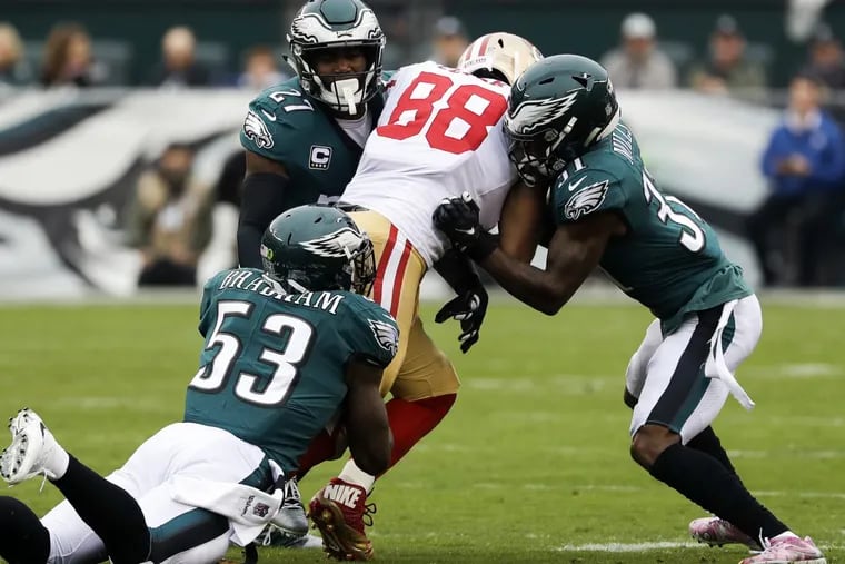 Eagles strong safety Malcolm Jenkins (right), outside linebacker Nigel Bradham and cornerback Jalen Mills stop  49ers tight end Garrett Celek during the first quarter.