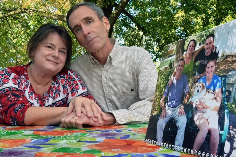 Annie and Bob Reynolds are seen next to a family photo of them and their children Tom and Molly taken a year earlier in the same spot in the backyard of their Flourtown home. Tom, 27, died from a heroin overdose in September.