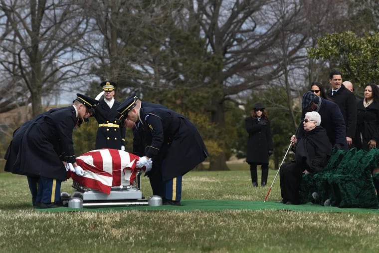 Marla Andrews (right) watches on Friday in Arlington National Cemetery as an honor guard lowers the casket carrying her father, Capt. Lawrence E. Dickson, a Tuskegee Airman whose remains were located in 2017 in Austria.