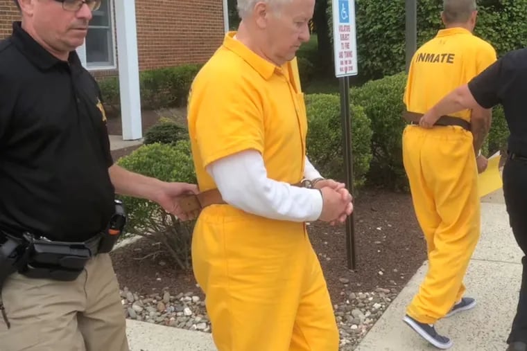 Ralph Miller, 71, is escorted out of district court in Doylestown on July 30 after a preliminary hearing. He's accused of sending explicit emails to an underage girl while in custody in federal prison.