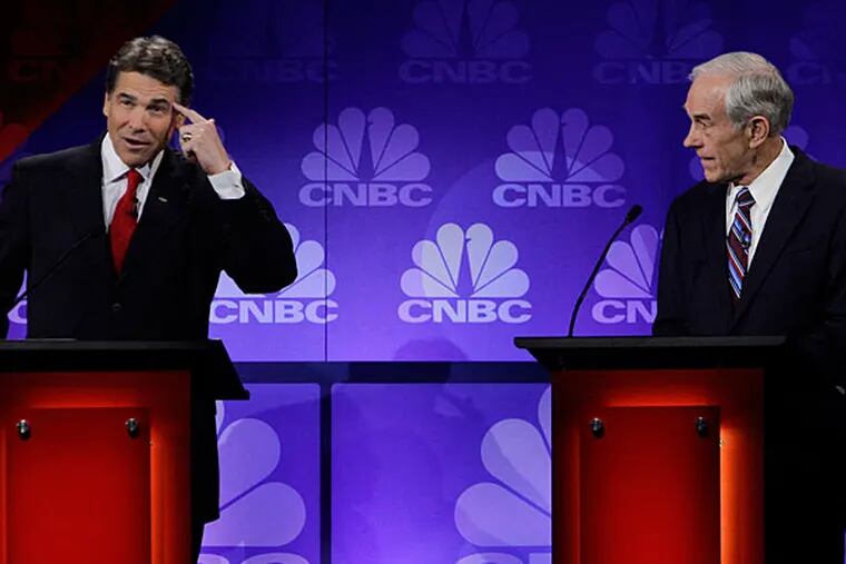 former Texas Gov. Rick Perry (left) shows Ron Paul what he's thinking of doing during one of the 1,000 GOP debates in 2012.